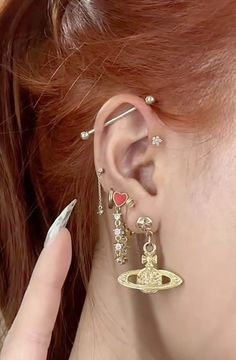 a close up of a person with ear piercings on their ears and wearing earrings