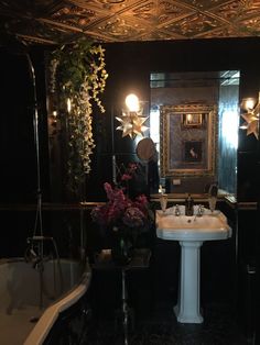 a bath room with a sink and a bath tub next to a mirror on the wall