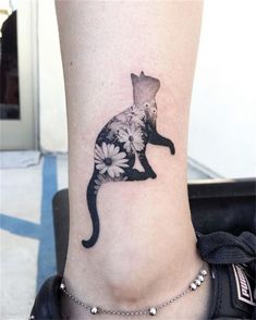 a cat tattoo on the leg of a woman