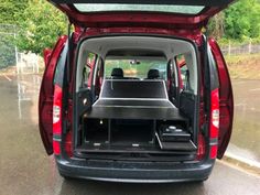 the back end of a red van with its trunk open