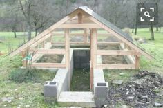 a chicken coop built into the side of a field