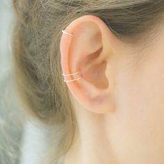 a close up of a person's ear with two thin rings