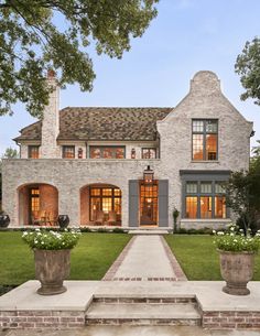 a house with two large planters in front of it and an entry way leading to the outside