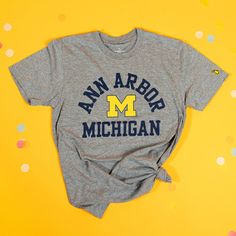 Rock your Ann Arbor pride with our exclusive Ann Arbor x Michigan Tee! This tee features a classic U of M vibe that perfectly captures the spirit of the U. Whether you're strolling through the Diag or grabbing coffee on Main Street, this tee is your go-to for showing off your hometown love in style. Super soft stonewashed tri-blend poly/cotton/rayon (50/25/25).Designed in Michigan by The Mitten State.Assembled in USA.Officially licensed by the University of Michigan. Michigan Apparel, U Of M, University Of Michigan, Kids Bath, Ann Arbor, Gilmore Girls, Main Street, Arbor, Corporate Gifts