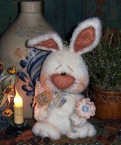 a white stuffed rabbit sitting next to a lit candle