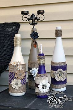 three bottles are decorated with flowers and burlaps on the outside of them