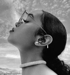 a black and white photo of a woman with her ear piercings in the air