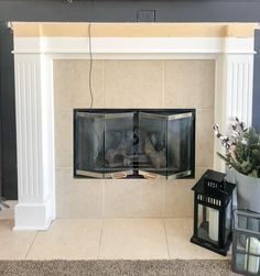 a fireplace with a mantle and two lanterns