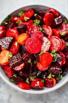 a bowl filled with beets and carrots on top of a table