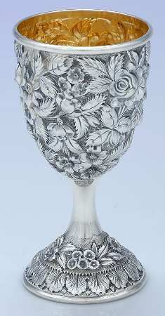 an ornate silver goblet with floral designs