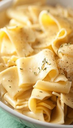 a white bowl filled with pasta on top of a green napkin