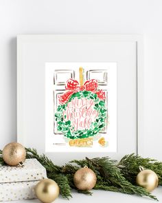 a christmas wreath with red bows and gold ornaments in front of a white framed art print