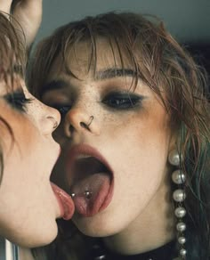 two women with their mouths open and piercings on