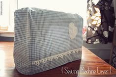 a blue and white checkered bag sitting on top of a wooden table next to a window