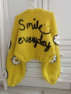 a yellow sweater with the words smile everyday written on it