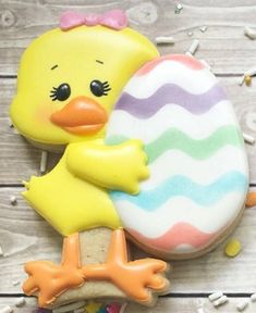 a decorated cookie with a rubber ducky holding an easter egg on it's back