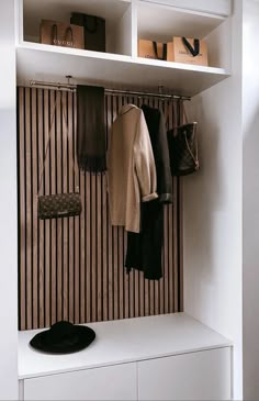 a coat rack with several coats hanging on it's hooks and two purses