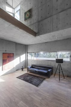 a living room with wood floors and concrete walls