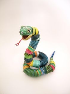 a toy snake is sitting on the ground with its mouth open and it's tongue out