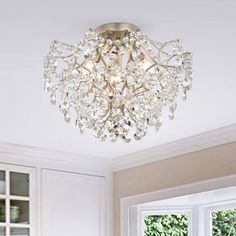 a chandelier hanging from the ceiling in a room with white walls and windows