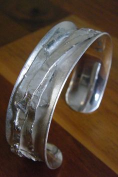 "Silver bracelet or bangle, wrist size 60 mm (2 3/8\"). Solid silver band in an anticlastic surface. The band it self has a frosted look. The decoration of the multiple silver composition is highly polished. The width of the bracelet is 19 mm (3/4\"). The total weight is about 50 grams. Your price for this bracelet includes the costs of shipping, with track & trace." Dream Accessories, Silver Cuff Bangle, Recycled Silver, Dremel, Cuff Bangles, Silver Cuff, Silver Band, Matching Earrings, Arm Band