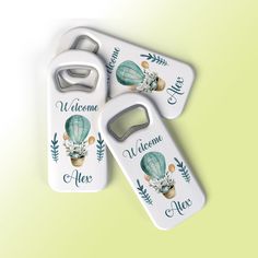 two bottle openers with the words welcome to me and an image of a hot air balloon