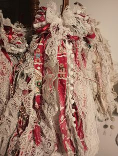 an elaborately decorated red and white dress hanging on a wall