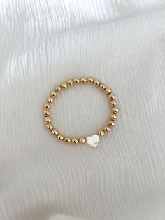 Mother of pearl heart on your choice of our 4mm or 6mm gold ball bracelet 14k gold filled Gold Ball Bracelet, Breclate Aesthetic, Everyday 14k Gold-filled Bracelets With Pearl Charm, Everyday 14k Gold Filled Bracelets With Pearl Charm, Everyday 14k Gold-filled Bracelet With Pearl Charm, Dainty Bracelet With Heart Charm And Round Beads, Valentine's Day Jewelry With Pearl Charm, Stackable Pearl Jewelry With Round Beads, Dainty Heart Charm Bracelet With Round Beads