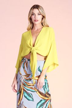 This sexy top is perfect for a night out, date night, vacation wear or after-hours. Pair with shorts, skirts, jeans, pants and with swimwear. Wear with pasties, bralettes, tank tops, bikinis or alone. The self-tie closure gives you freedom to secure the top in the front, side or back, depending on your liking. Deep v neckline 3/4 Sleeves Kimono-style body Tie-front closure Crinkle chiffon-like fabric 100% Polyester Made in USA Devin is 5'8" and is wearing a size small. SKU #: T-6873 Stretch V-neck Crop Top For Vacation, Chic Triangle Top For Beach, Chic Triangle Top For The Beach, Chic Triangle Top For Day Out, Trendy V-neck Crop Top For Beach, Spring Flirty V-neck Crop Top, Flirty V-neck Spring Crop Top, Spring Vacation V-neck Crop Top, Chic Triangle Top Crop Top For Day Out