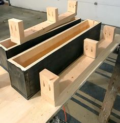 two wooden boxes sitting on top of a table next to some wood planks and wires