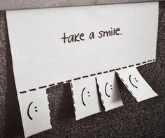 a piece of paper with the words take a smile on it next to four faces