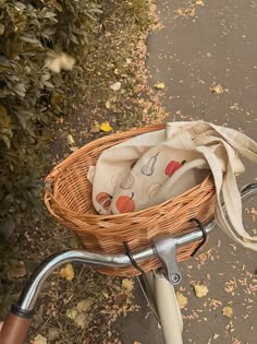 a wicker basket on the handlebars of a bicycle with a bag in it