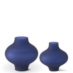 two blue vases sitting next to each other on a white surface with no one in it