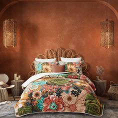 a bed in a room with brown walls and flowers on the comforter, along with wicker lamps