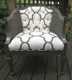 a white and black chair sitting on top of a wooden deck