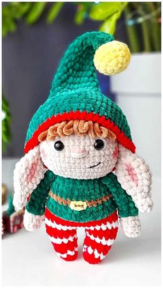 a crocheted stuffed animal wearing a green and red outfit