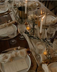 the table is set with candles, plates and napkins for an elegant dinner party