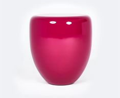 a bright pink vase sitting on top of a white table