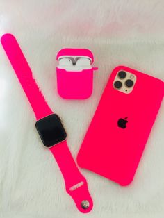 an apple watch and pink iphone case sitting on a white surface next to each other