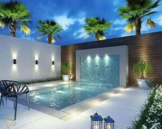 an outdoor swimming pool surrounded by palm trees and potted plants with lights on the side