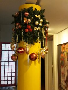 a tall yellow pole with ornaments hanging from it