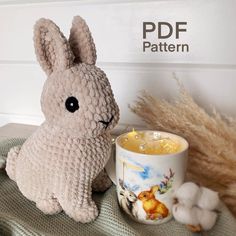 a stuffed rabbit sitting next to a coffee mug