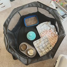 a black table topped with lots of food and bowls on top of carpeted floor