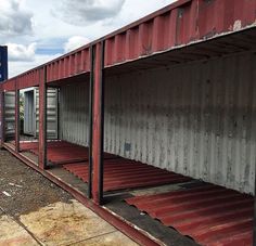 an empty storage area with red and white containers on the ground next to a blue sign