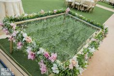 an arrangement of flowers and greenery is arranged on the ground at a wedding reception