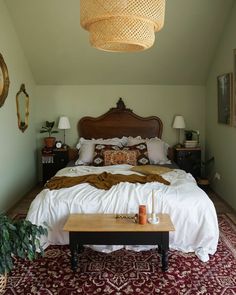 a bedroom with a large bed and wooden headboard on top of a red rug