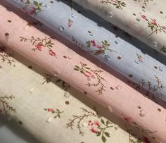 four different colors of fabric with small flowers and dots on them, all lined up together