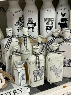 many white milk bottles with black and white designs on them