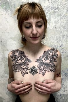 a woman with tattoos holding her chest