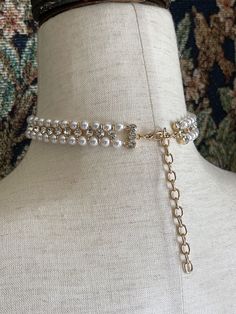 Our most luxurious adornment to date; this faux-pearl-beaded choker necklace has double rows of pearl beads adorned with glass crystal accents, a large encircled faux pearl cabochon, and gold colored adjustable hardware to fit your neck perfectly. Sizing: One Size Neck Circumference 12-16 Inches / 30-40 CentimetersAdjustable Claw Clasp Closure Adjustable Pearl Embellished Choker Necklace, Formal Beaded Choker In Pearl White, Pearl Embellished Choker For Parties, Formal Beaded Pearl White Choker, Glamorous Round Pearl Jewelry, Formal Pearl White Beaded Choker, Pearl Beaded Choker Jewelry, Beaded Pearl Choker Jewelry, Pearl Embellished Choker